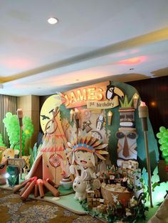 an elaborate birthday display in the middle of a room with balloons and decorations on it