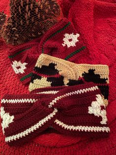 knitted hats and scarves laid out on top of a red blanket with white stars