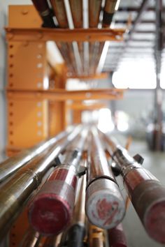 many metal pipes are lined up in a warehouse