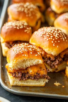 several cheeseburger sliders on a baking sheet