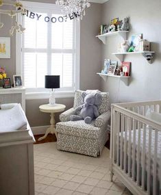 a baby's room with a crib, chair and window