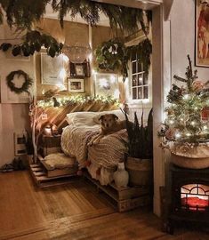 a bedroom decorated for christmas with lights and greenery