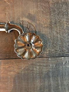 an old metal door handle on a wooden surface