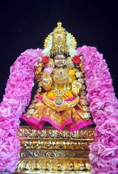 the statue is adorned with pink flowers