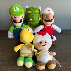 several stuffed toys sitting on top of a wooden table