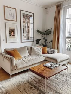 a living room filled with furniture and pictures on the wall above it's windows