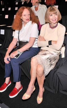 two women sitting next to each other at a fashion show