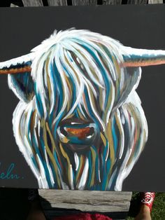 a painting of a white cow with blue, yellow and orange stripes on it's face