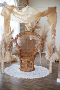 a wicker chair sitting on top of a wooden floor next to tall dry grass