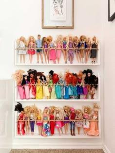 there are many barbie dolls on the shelves in this room, all lined up and ready to be played