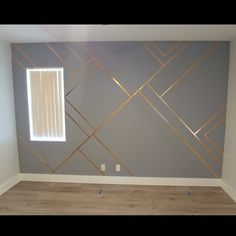 an empty room with wood floors and gray walls