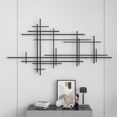 a black shelf sitting on top of a table next to a wall mounted art piece