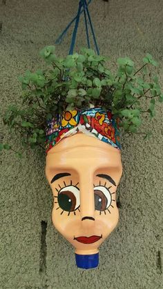 a planter that has been placed on the ground with a face painted on it