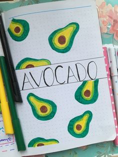 a notebook with an avocado drawn on it next to some markers and pens