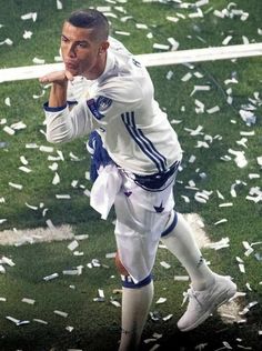 a man standing on top of a field holding a soccer ball and confetti