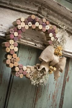 a wreath made out of wine corks hanging on a door