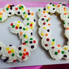 a cake shaped like the number 50 with white frosting and multicolored candies