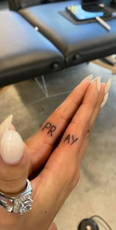 two people holding hands with tattoos on their fingers and one has the word love written on it