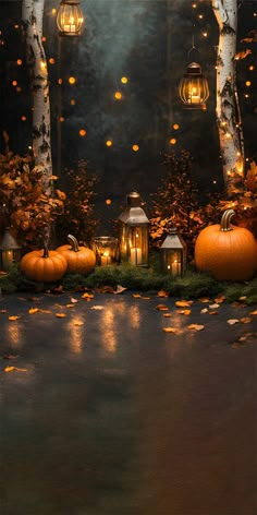 pumpkins and lanterns are lit up on the ground in front of trees with lights