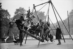 an old black and white photo of people on a swing set