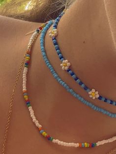 the back of a woman's neck with multicolored beads and flowers on it