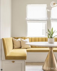 a living room with yellow couches and a white table