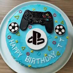 a blue birthday cake with a video game controller on it and happy birthday written in the middle