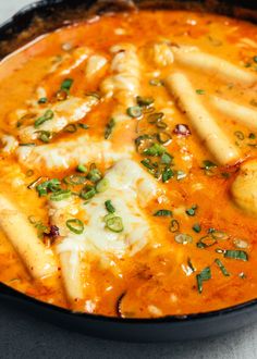 a black bowl filled with pasta and cheese