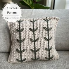 a crocheted pillow with an arrow pattern on the front and back, sitting on a couch