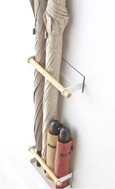 a pair of umbrellas are hanging on the wall next to a coat rack and umbrella holder