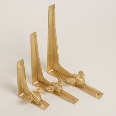 three golden metal brackets on a white background