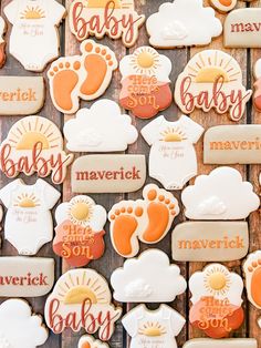 some cookies that are shaped like baby feet and footprints with words on them, all decorated in different colors