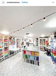 the interior of a book store with lots of books on shelves and lights hanging from the ceiling