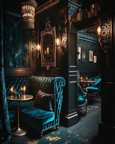 a dark room with blue velvet couches and tables