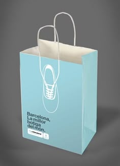 a blue shopping bag with a shoe on the front and bottom, in white paper