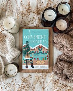 a book sitting on top of a blanket next to candles and blankets in front of it