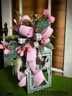 a vase filled with pink flowers on top of a green table