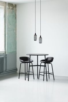 two black chairs sitting at a table in front of a radiator and window