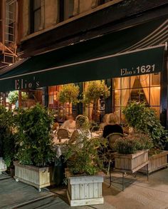 an outdoor cafe with potted plants outside