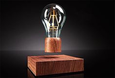 a light bulb sitting on top of a wooden block in front of a black background