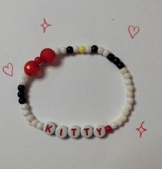 a beaded bracelet with the word kitty on it and two beads attached to it