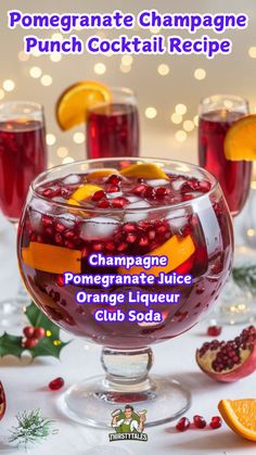 pomegranate champagne punch cocktail recipe in a glass with orange slices and cranberries