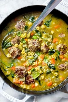 a bowl filled with meatballs and pasta soup