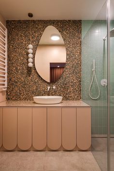 a bathroom with a sink, mirror and shower