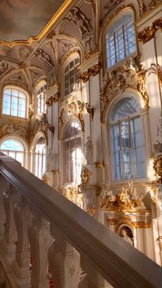 an ornate building with gold and white decorations on the walls, stairs and balconies