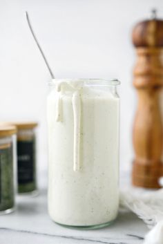 a jar filled with white liquid sitting on top of a table