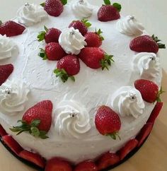 a cake with white frosting and strawberries on top