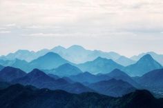 blue mountains are seen from the top of a hill