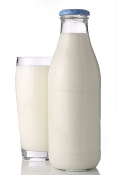 a glass and bottle of milk sitting next to each other