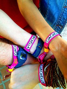 three people wearing wristbands with the words coach on them are sitting next to each other